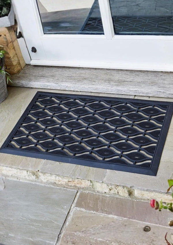 Textured doormat with geometric pattern on a stone patio