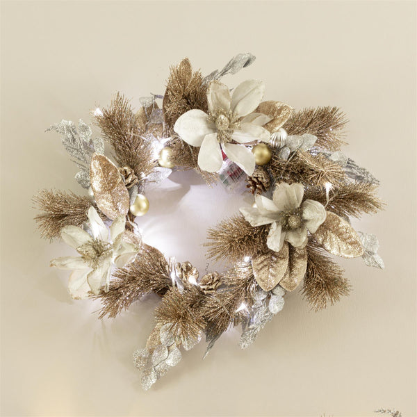 Decorative wreath with gold and silver elements on a beige background