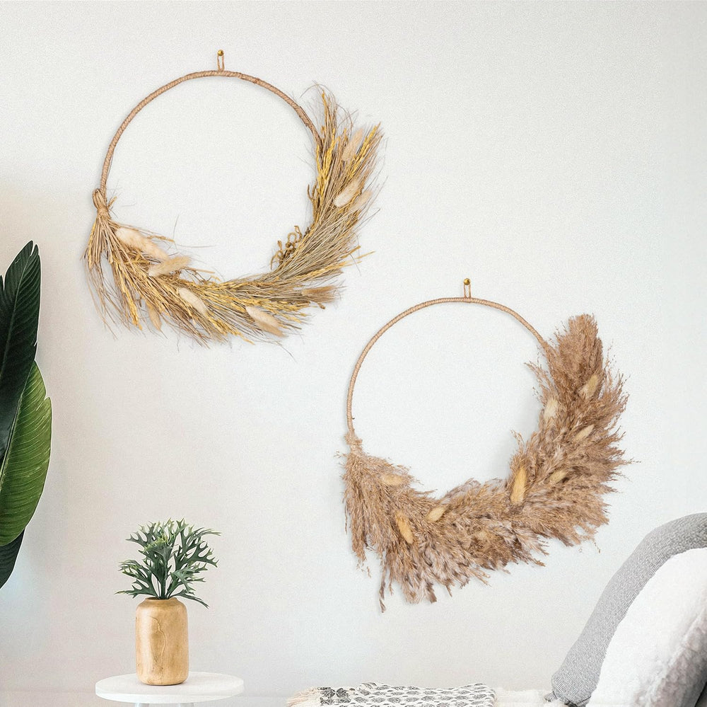 Two decorative wreaths on a wall with a small plant and chair in the foreground.