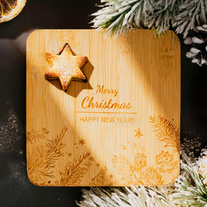 Wooden cutting board with Christmas decorations and a star-shaped cookie.