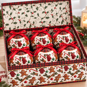 A Christmas-themed gift box containing six decorative round ornaments. The ornaments are white with red plaid ribbons, red Santa hats, candy canes, and green holly accents.