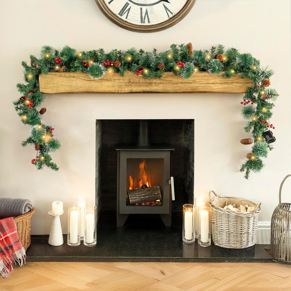 Decorated fireplace with Christmas garland, candles, and a clock on the wall.