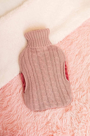 Knitted pink baby sweater on a pink textured surface