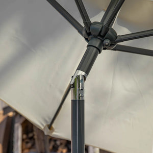Close-up detail of a patio umbrella showing the dark gray metal pole, joint, and canopy fabric.