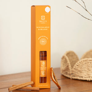 Baltus winter spice and orange diffuser packaging on a wooden surface with cinnamon sticks.