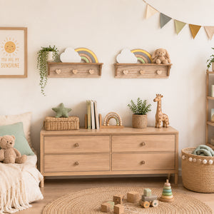 A styled children's nursery featuring a light natural wood dresser with six drawers, mounted on a warm off-white wall. Above the dresser, two matching wooden floating shelves hold a cloud, a rainbow, and a plush bunny.