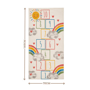 A rectangular rug or mat shown flat against a white background, with dimension arrows indicating 140 cm tall and 70 cm wide. The rug has a cream base with a playful hopscotch-style number grid, rainbow arcs, gray clouds, small red hearts, and a smiling sun.