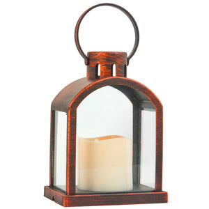 A rustic-style lantern with a dark brown distressed finish, clear glass panels, and a cream-colored flameless LED candle inside, set against a plain white background.