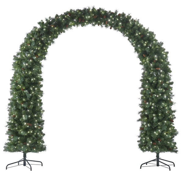 A green artificial Christmas tree arch with warm white string lights and small pinecones, displayed on a black metal stand against a white background.