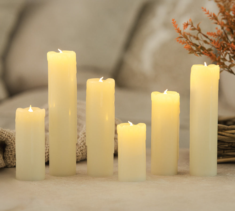 Set of six white candles on a textured surface with a blurred background
