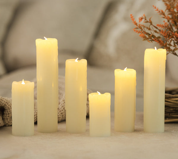 Set of six white candles on a textured surface with a blurred background