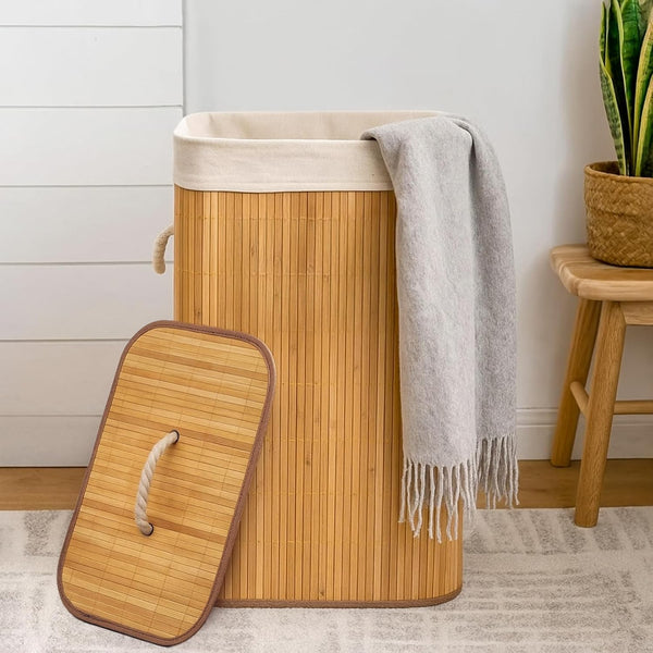 Bamboo laundry basket with a gray towel draped over it in a room setting.