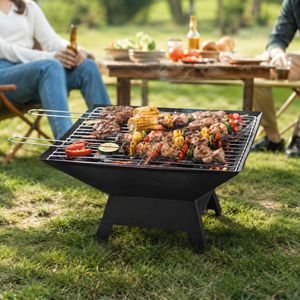 Barbecue grill with food on a grassy outdoor setting