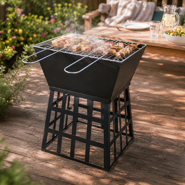 A black metal outdoor grill with a slotted stand, shown on a wooden deck with chicken skewers cooking on the grate. A patio table and plants are visible in the background.