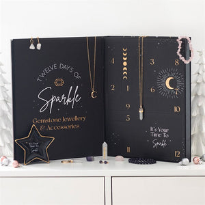 Black advent calendar with gemstone jewellery and accessories on a white surface
