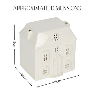 A small white house-shaped ceramic container or ornament shown with dimension arrows and labels reading 12 cm height, 9 cm width, and 11 cm depth under the heading 'APPROXIMATE DIMENSIONS'.