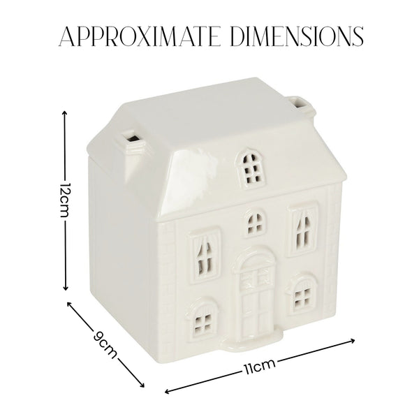 A small white house-shaped ceramic container or ornament shown with dimension arrows and labels reading 12 cm height, 9 cm width, and 11 cm depth under the heading 'APPROXIMATE DIMENSIONS'.