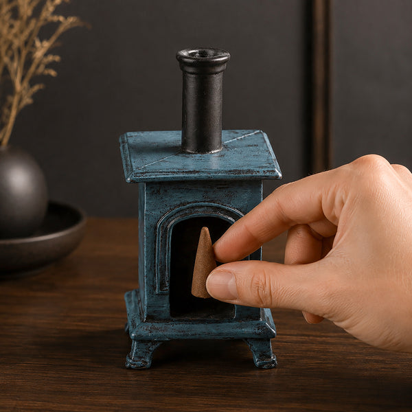 stove ornament and a hand placing an incense cone in it
