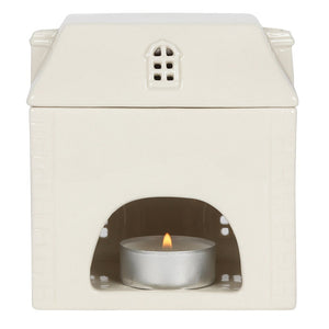 White ceramic oil burner with a small candle inside on a white background