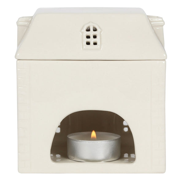 White ceramic oil burner with a small candle inside on a white background