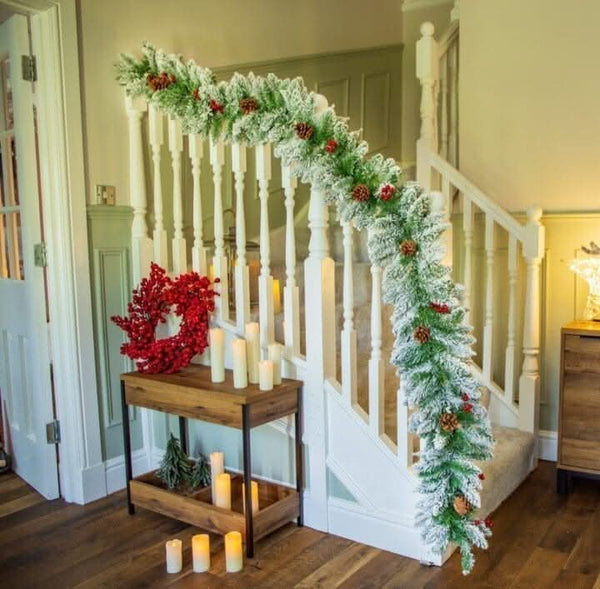 Snow tipped Christmas garland displayed across a fireplace