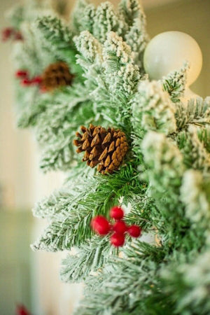 Red berry and pinecone garland displayed on a mantelpiece