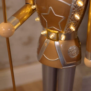 Large metal nutcracker decoration beside Christmas tree