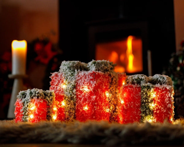 Red and green festive gift boxes glowing with warm white lights