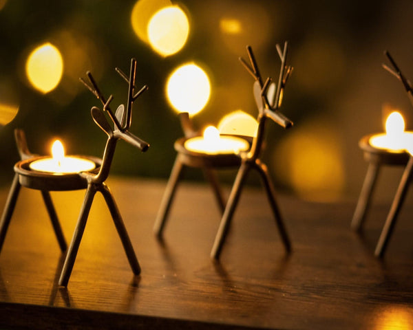 Six festive reindeer candle holders displayed together