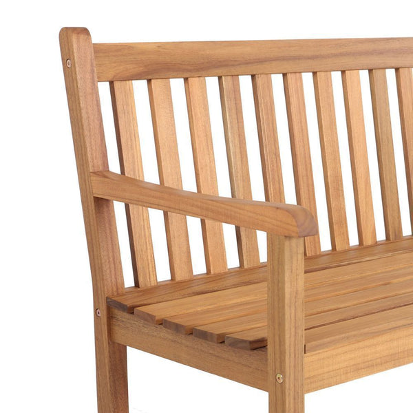 Close-up of a wooden slat bench with a warm medium brown finish, showing the backrest, armrest, and seat slats on a plain white background.