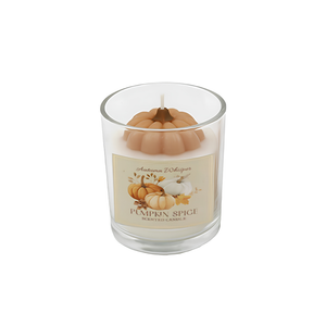 A 'Pumpkin Spice' scented soy wax candle in a clear glass jar, featuring a decorative tan pumpkin-shaped wax insert and a cream-colored label with illustrations of pumpkins.