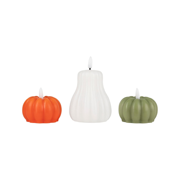 Three pumpkin-shaped flameless LED candles in orange, white, and sage green, arranged side-by-side on a solid white background.