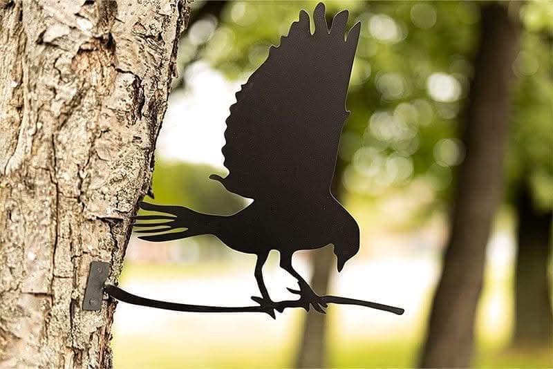 Flying bird silhouette metal decoration mounted on garden tree