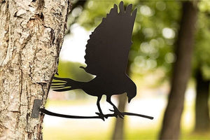 Flying bird silhouette metal decoration mounted on garden tree