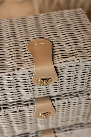 Close-up of a wicker basket with a beige handle and latch.