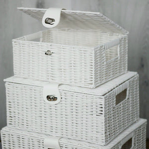 Stack of white wicker storage baskets with lids on a neutral background