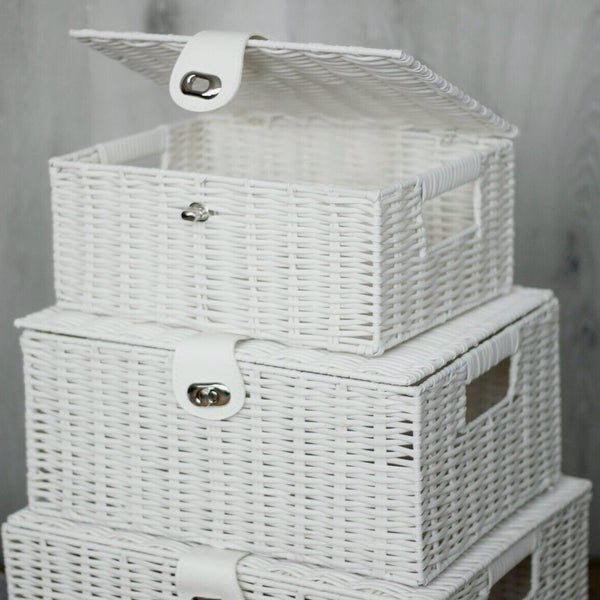 Stack of white wicker storage baskets with lids on a neutral background