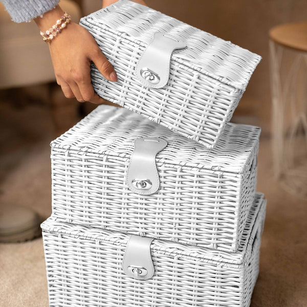 White wicker storage baskets with silver locks on a neutral background