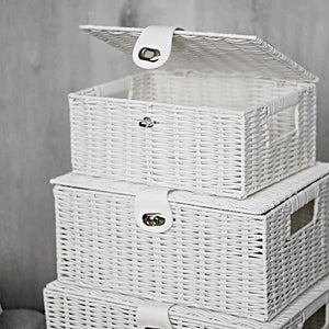 Set of white wicker storage baskets with lids on a neutral background
