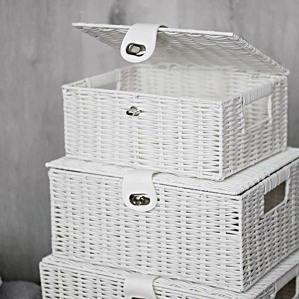 Set of white wicker storage baskets with lids on a neutral background