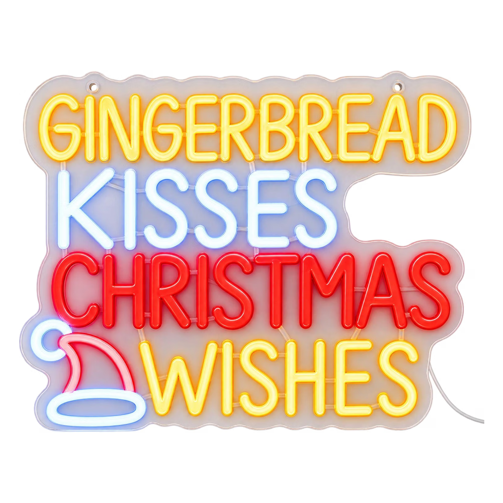 A glowing LED neon-style wall sign with the phrase “GINGERBREAD KISSES CHRISTMAS WISHES” in yellow, blue, and red letters, mounted on a beige wall above a wooden table with holiday decorations.