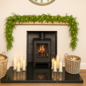Decorative fireplace with greenery, candles, and baskets in a cozy room.