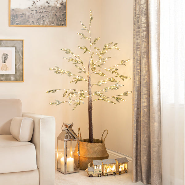 Decorative indoor tree with lights in a living room setting.