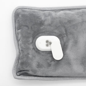 A gray plush heated pad with a white remote control on a plain white background.