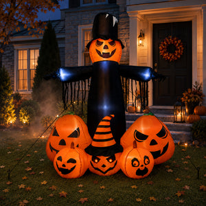 An inflatable Halloween yard decoration set displayed on a lawn in front of a house. The set includes a tall black-and-orange scarecrow with glowing blue arms and five carved jack-o'-lantern pumpkins in front, including one with a small orange-and-black striped witch hat.
