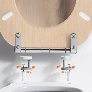 Close-up of a toilet lid hinge with a light wood toilet seat, chrome metal bracket, and white toilet bowl. Orange arrows and the text '360°' indicate swivel adjustment of the hinges.
