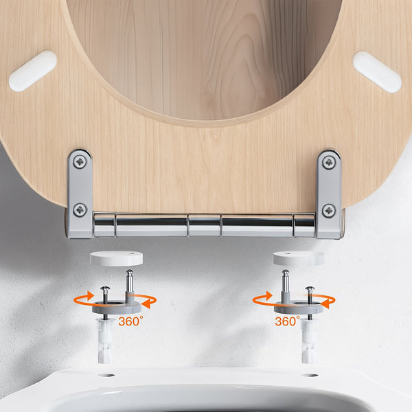 Close-up of a toilet lid hinge with a light wood toilet seat, chrome metal bracket, and white toilet bowl. Orange arrows and the text '360°' indicate swivel adjustment of the hinges.