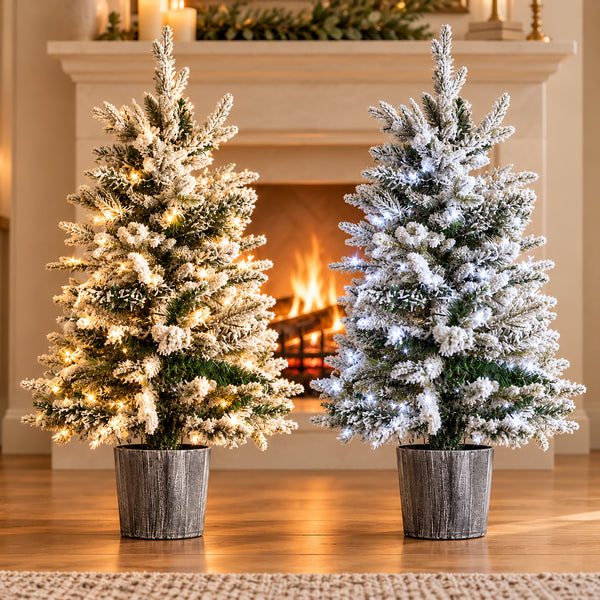 Pair of 3ft pre lit Christmas trees showing warm and cool white LED lighting options beside a fireplace.