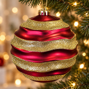Close-up of a 15cm red Christmas bauble featuring wavy gold glitter bands and a gold hanging cord.