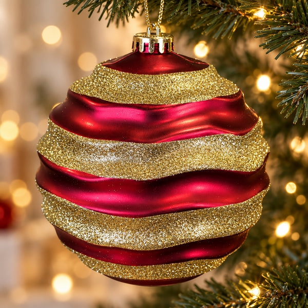 Close-up of a 15cm red Christmas bauble featuring wavy gold glitter bands and a gold hanging cord.